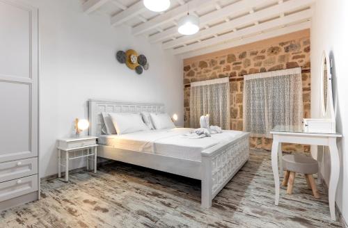 - une chambre blanche avec un grand lit et 2 tables dans l'établissement Villa del Capo Suites, à Rhodes