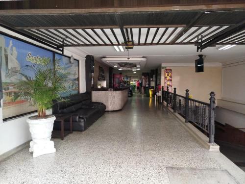 Hotel Sevilla Plaza في بوكارامانغا: لوبي فيه كنب وزرع في ابريق