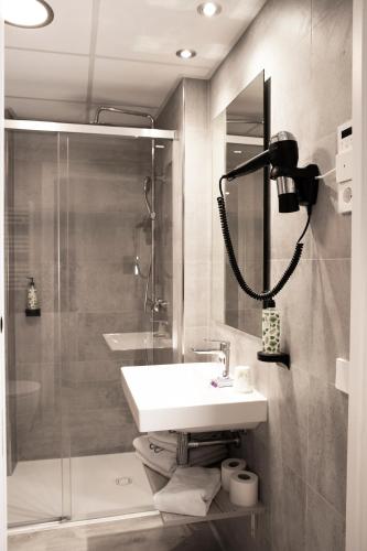 a bathroom with a white sink and a shower at Hotel Dos Rios Origen in Aínsa