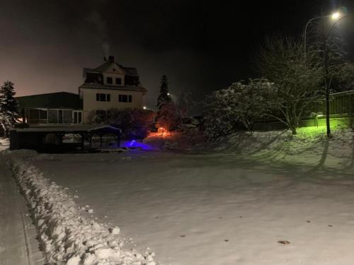 a house with a snow covered yard at night at Villa mit Pool und Grillplatz in Regensburg in Regensburg