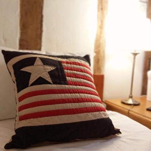 an american flag pillow sitting on top of a bed at The Ram at Tivetshall in Tivetshall Saint Margaret