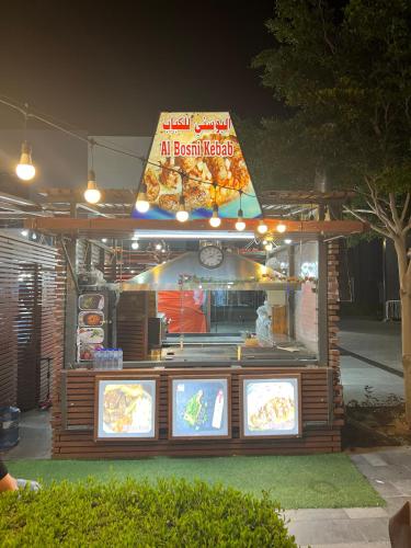 a food stand with a sign on top of it at Small Room shared bath with beach access for single person or short stay couplesغرفة صغيرة مع حمام مشترك مع إمكانية الوصول إلى الشاطئ لشخص واحد أو للأزواج الذين يقيمون لفترة قصيرة in Ajman