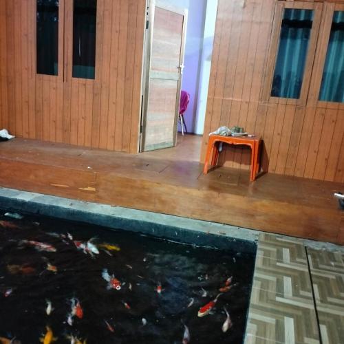 a koi pond in a building with a table next to it at Ayu Park in Ternate