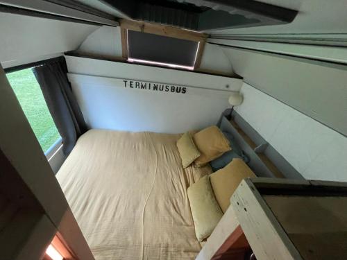 ein kleines Bett auf der Rückseite eines Zugwagens in der Unterkunft TERMINUSBUS in Crèvecoeur-le-Grand