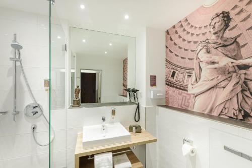 
a bathroom with a sink, mirror, and bathtub at Ibis Styles Trier in Trier

