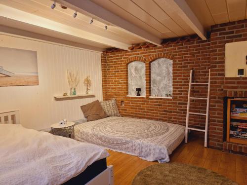 een slaapkamer met een bed en een bakstenen muur bij Ferienhaus im Moor in Wiesmoor