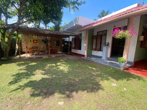een achtertuin van een huis met een grasveld bij Mallika City Villa in Negombo