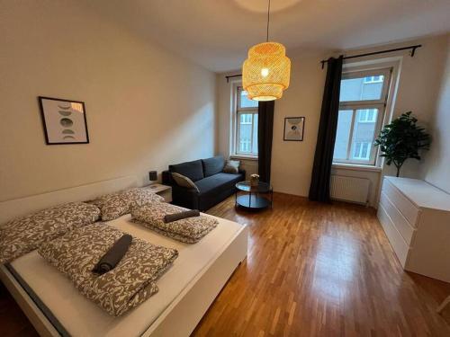 ein Wohnzimmer mit einem Bett und einem Sofa in der Unterkunft 90 m2 Spacious Apartment - 15 min to Center in Wien