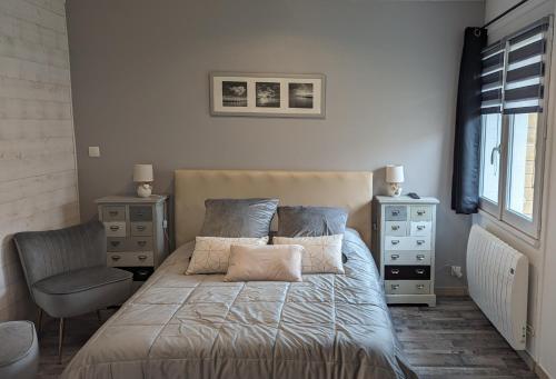 a bedroom with a bed with a chair and a window at Opale Baie in Berck-sur-Mer