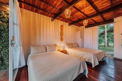 2 camas en una habitación con ventana en Hotel Pietrasanta, en Guatapé