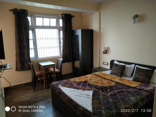 een hotelkamer met een bed en een raam bij Sagarmatha Homestay in Darjeeling