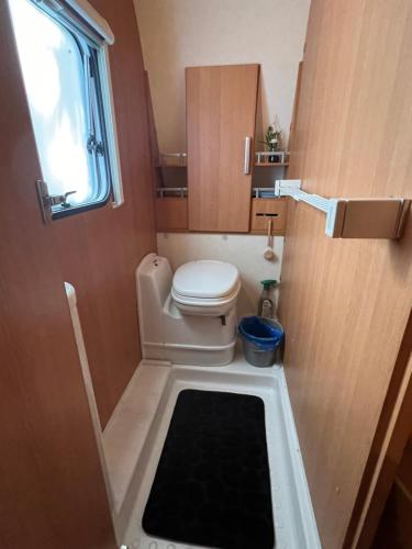 a small bathroom with a toilet and a window at Camping Alex in Cadenazzo