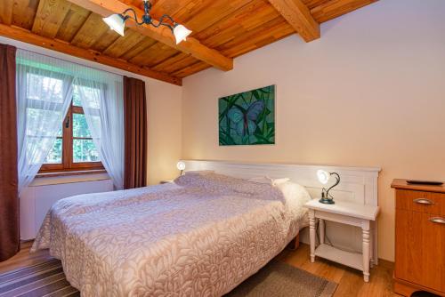 Schlafzimmer mit einem Bett, einem Tisch und einem Fenster in der Unterkunft Vila Banga in Nida