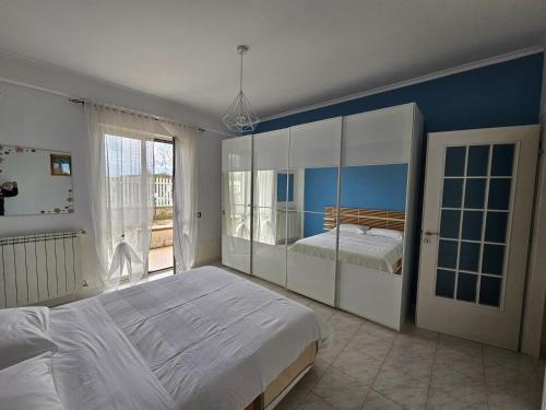een slaapkamer met een groot bed en een groot raam bij Casa delle Calle in Torre Annunziata