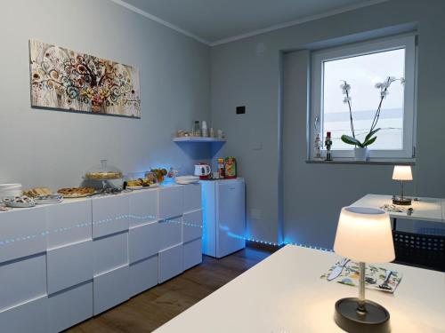 NoepoliにあるNirvana Bed and Breakfast Experienceの青いキャビネットと窓付きのキッチン