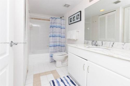 a white bathroom with a toilet and a sink at Entire Condo in Brickell steps from Brickell City Centre in Miami