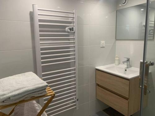 une salle de bain blanche avec un lavabo et une douche dans l'établissement Duplex Argenté T3 à 20 min de Paris Saint Lazare, à Argenteuil