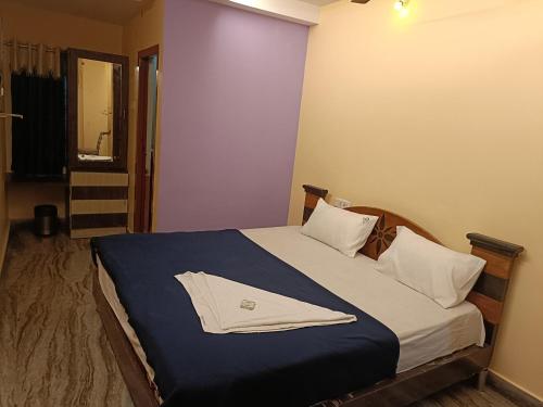 ein Schlafzimmer mit einem Bett und einem Bademantel. in der Unterkunft Hotel Dakshin Sea Paradise in Visakhapatnam