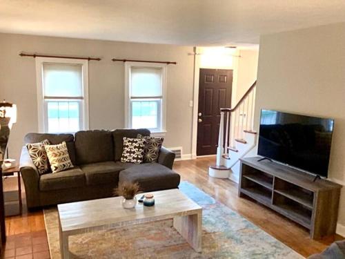 a living room with a couch and a flat screen tv at Cute 2 Bedroom Home - Huge backyard, near downtown! in Cleveland