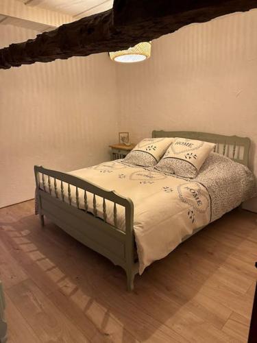 - une chambre avec un lit vert et des oreillers dans l'établissement Petite maison, à Plesder