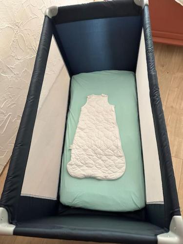 une chaise noire et verte avec une couverture dans l'établissement Petite maison, à Plesder