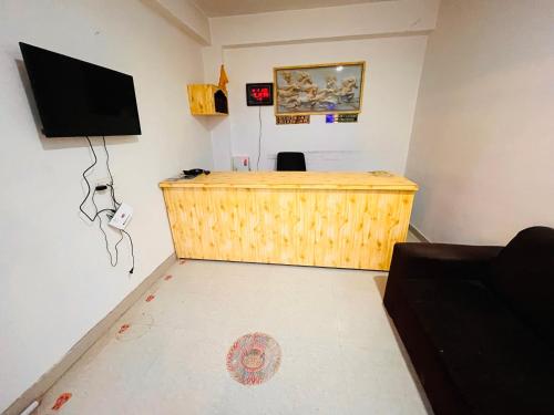 Habitación con escritorio de madera y TV de pantalla plana. en Solank Hotel & Cafe en Amritsar