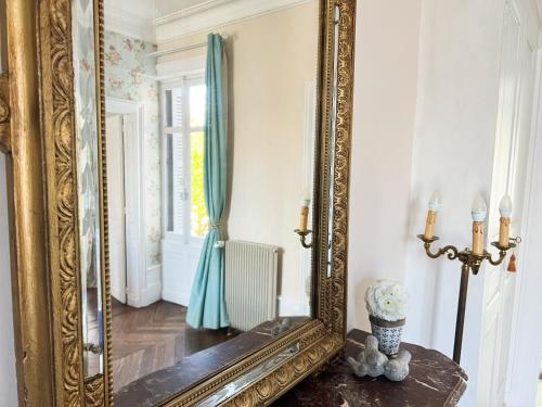 un espejo de oro ornamentado sobre una mesa en una habitación en Closerie la Fontaine en Savigné-sur-Lathan