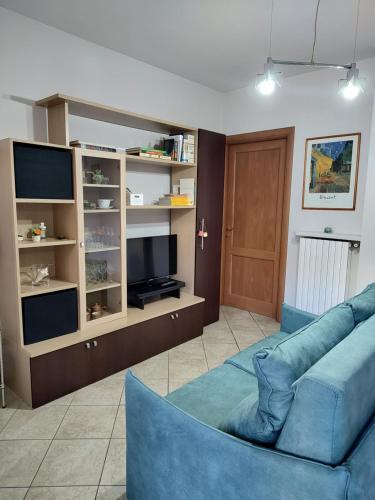 sala de estar con sofá azul y TV en Bilocale con ampio terrazzo en Bra