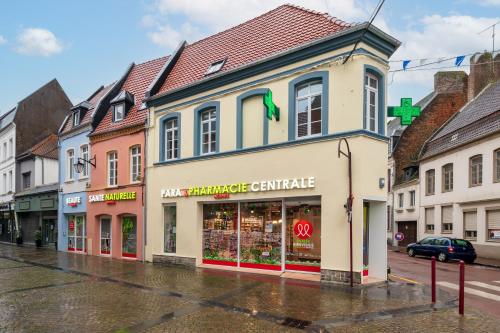 a street with a store on a rainy street at Hesdin Appart Holidays 4 in Hesdin