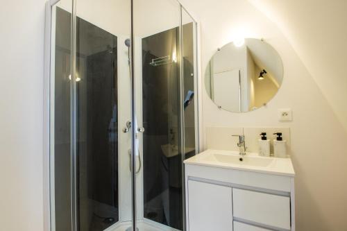 a bathroom with a shower and a sink and a mirror at Hesdin Appart Holidays 4 in Hesdin