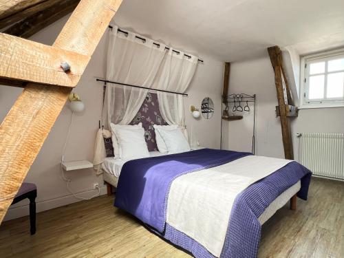 1 dormitorio con 1 cama con edredón azul y blanco en Closerie la Fontaine en Savigné-sur-Lathan