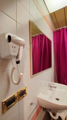 a bathroom with a sink and a pink shower curtain at Hotel Palace Masoanri's in Reggio Calabria