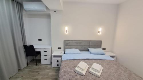 ein Schlafzimmer mit einem Bett mit zwei weißen Handtüchern darauf in der Unterkunft AIRPORT-TAXI-PARKING-Card in Chişinău