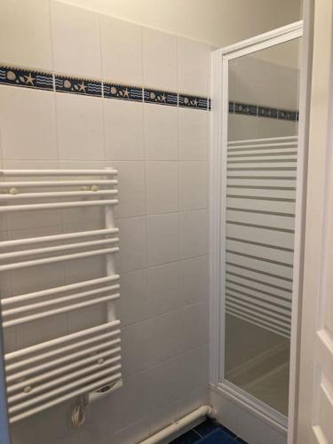 une douche avec une porte vitrée dans une salle de bain dans l'établissement Appartement cosy proche rue piétonne et plages, à Capbreton