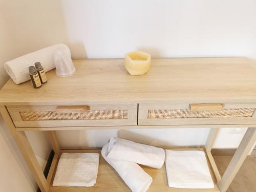 a wooden table with towels and a candle on it at Source de la Vallée in Sadroc