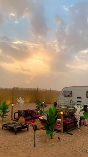 stół piknikowy na pustyni z furgonetką w tle w obiekcie كرفان قمر الليل الملكي مع ضيافة vip w Rijadzie