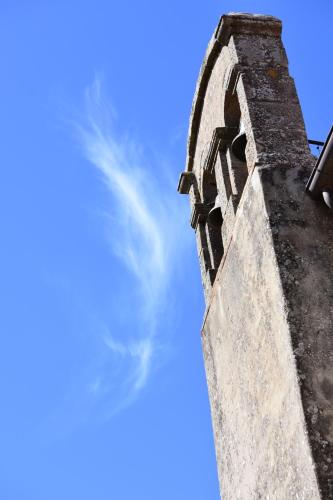 una torre dell'orologio con un cielo blu sullo sfondo di HOME L'UPUPA AMIATA a Salaiola
