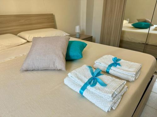 a bed with towels and blue bows on it at Il Quarzo Azzurro in Càbras