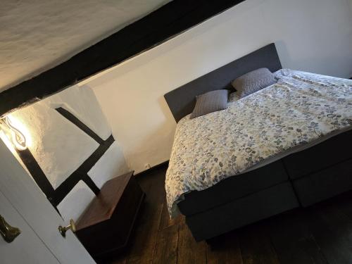 a bedroom with a bed and a wooden floor at Gite Ardennes Au coin du feu jacuzzi sauna et nature in Jalhay