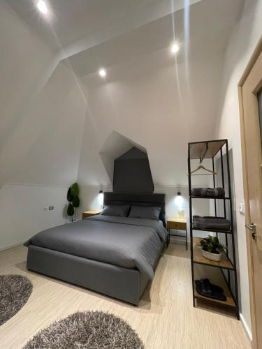 ein Schlafzimmer mit einem großen Bett und einem Regal in der Unterkunft POG Apartments in Tirana