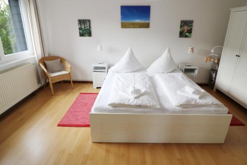 Cama blanca en habitación con alfombra roja en Ferienwohnung im Haus Rhea am Südhang- Feldberg- Falkau, en Vorderfalkau