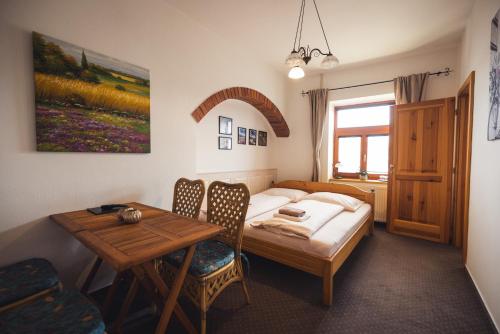 インドルジフーフ・フラデツにあるPenzion U Papouškůのベッドルーム1室(ベッド1台、テーブル、テーブル、椅子付)