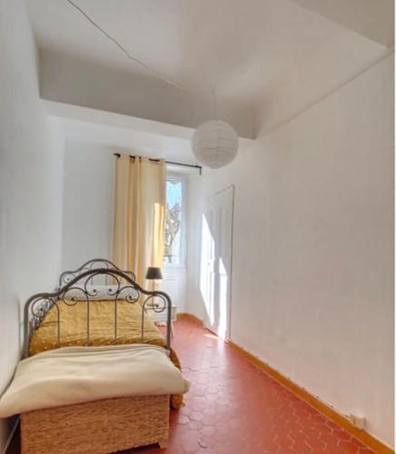 Cette chambre dispose d'un lit et d'un couloir avec une fenêtre. dans l'établissement Charmant appartement lumineux, au Muy