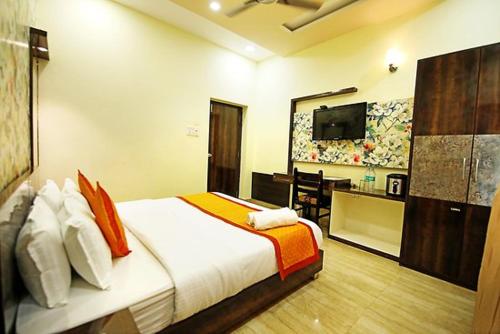Schlafzimmer mit einem Bett, einem Schreibtisch und einem TV in der Unterkunft HOTEL BITTY KRISHNA in Jaipur