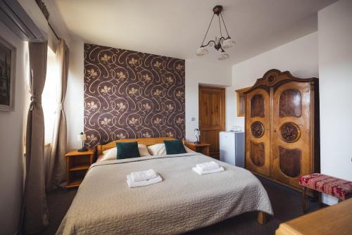 a bedroom with a large bed with a large wooden headboard at Penzion U Papoušků in Jindrichuv Hradec