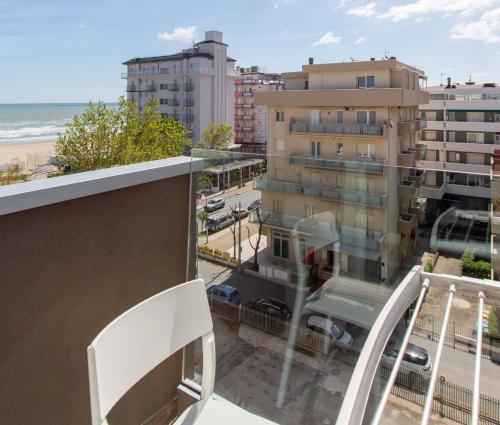 a balcony with a view of the beach and buildings at Hotel Grazia Riccione in Riccione