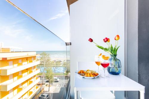 un tavolo con un cesto di frutta e due bicchieri di vino di Hotel Grazia Riccione a Riccione