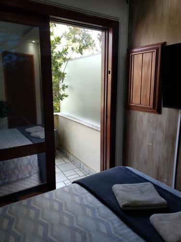 a bedroom with a bed and a large window at Pousada Monte Sião in Sao Paulo