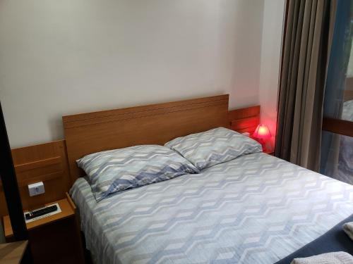 a bed with a wooden headboard in a bedroom at Pousada Monte Sião in Sao Paulo