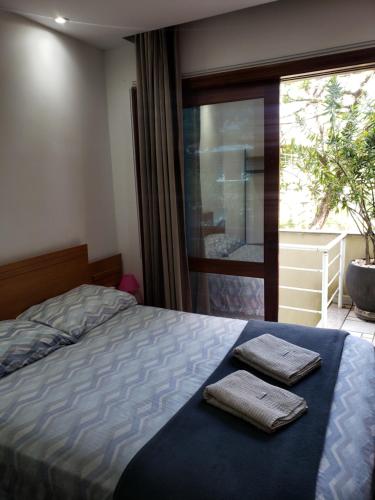 a bedroom with a bed with two towels on it at Pousada Monte Sião in Sao Paulo